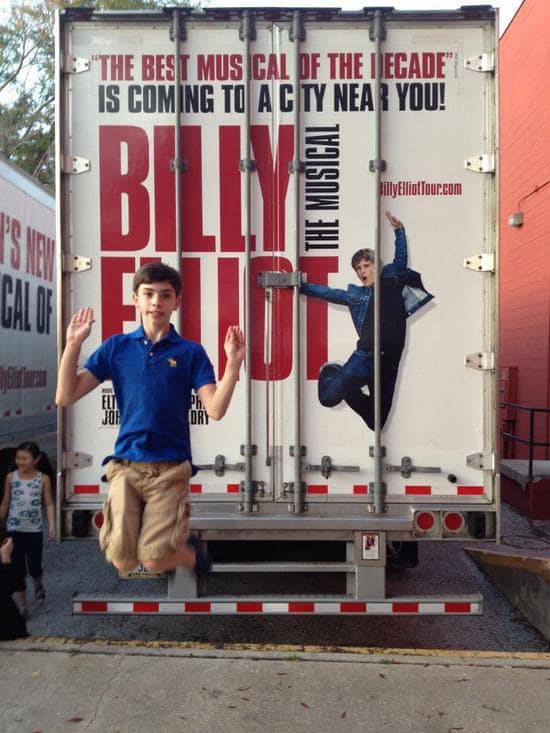 Zach Does the Billy Jump Beside Tour Trucks