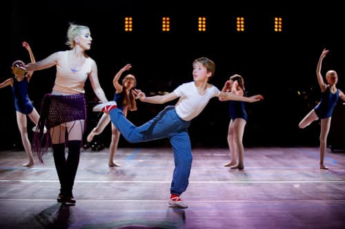 Mrs. Wilkinson (Åsa Fång) teaching Billy (Grim Lohman) ballet in class with the Ballet Girls.